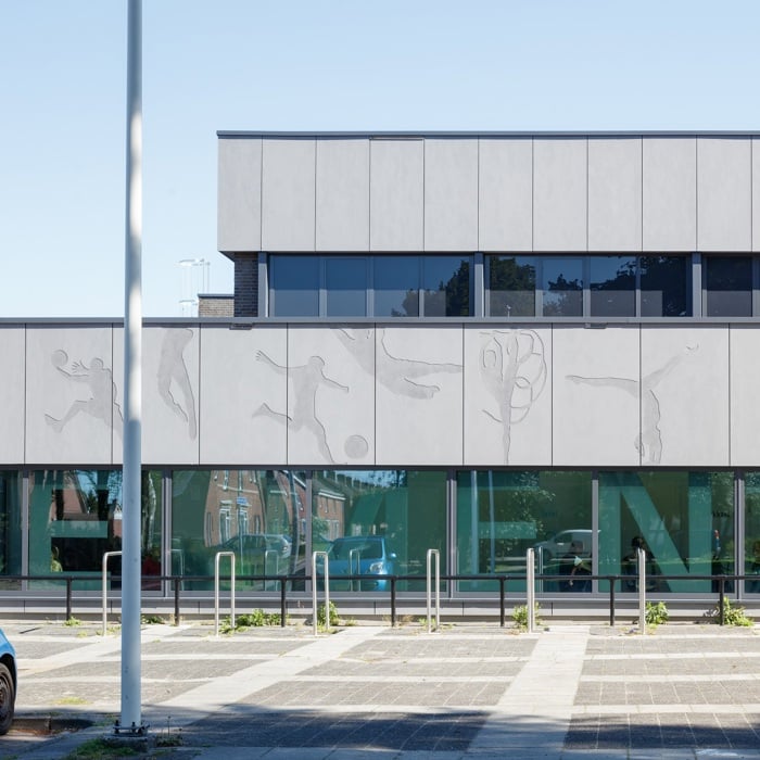 Des figures de sport gravées dans la façade donnent une dynamique unique au hall des sports de Muntendam, aux Pays-Bas